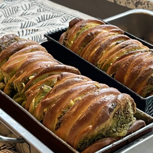 Zwei goldbraun gebackene Bärlauch Abreißbrote in Kastenformen